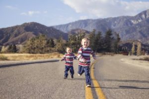 Siblings running in street
