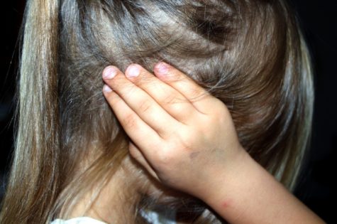 Child holding her ears