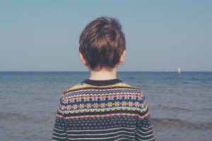 Young boy looking out at the ocean