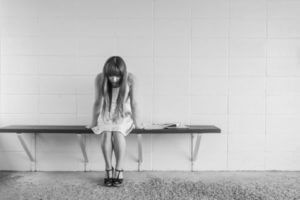 Sad girl sitting alone on bench