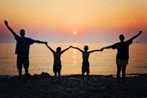 Family on beach vacation at sunset