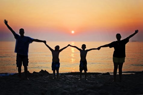 Family on beach vacation at sunset