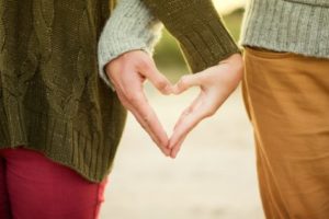 Couple holding hands to form heart