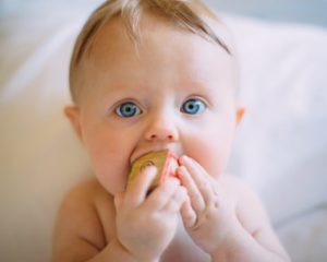 Cute baby boy with block in his mouth