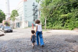 Woman walking in street with child