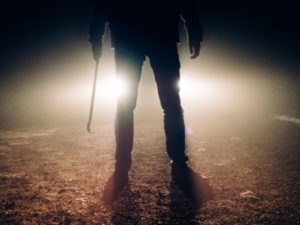 Creepy man with crowbar in front of headlights. Seeking revenge?