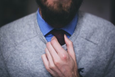 Man fixing tie in mirror