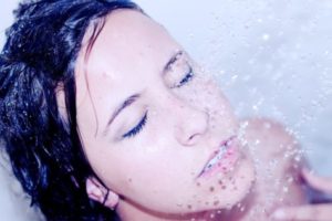 Woman washing her face in the shower