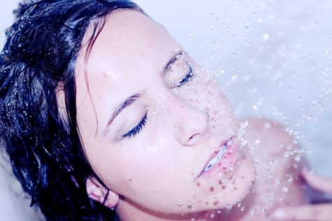 Woman washing her face in the shower