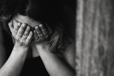 Sad woman with face in hands