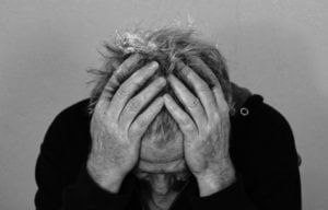 Man battling headache, stress
