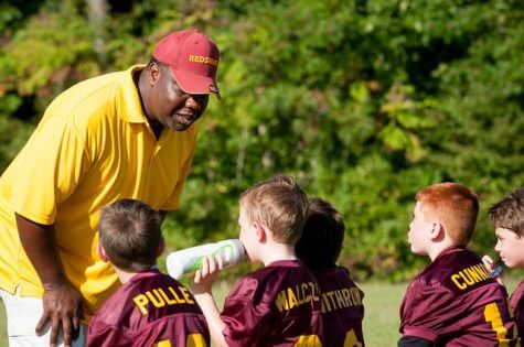 Coach talking to youth football team