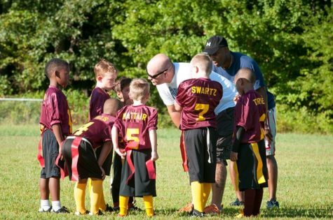 Coaches talking to youth football team
