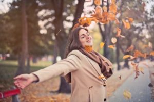 Happy woman throwing leaves