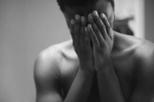 Black teen holding hands on face