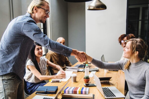 Co-workers shaking hands in office