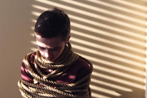 Young child tied up with rope