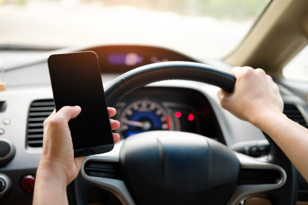 Distracted driving: person using phone behind wheel