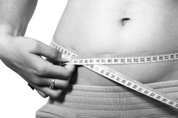 Woman measuring body fat or waist size