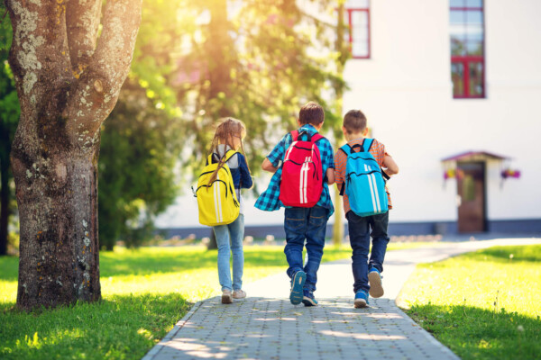 Children walking to school with backpacks on