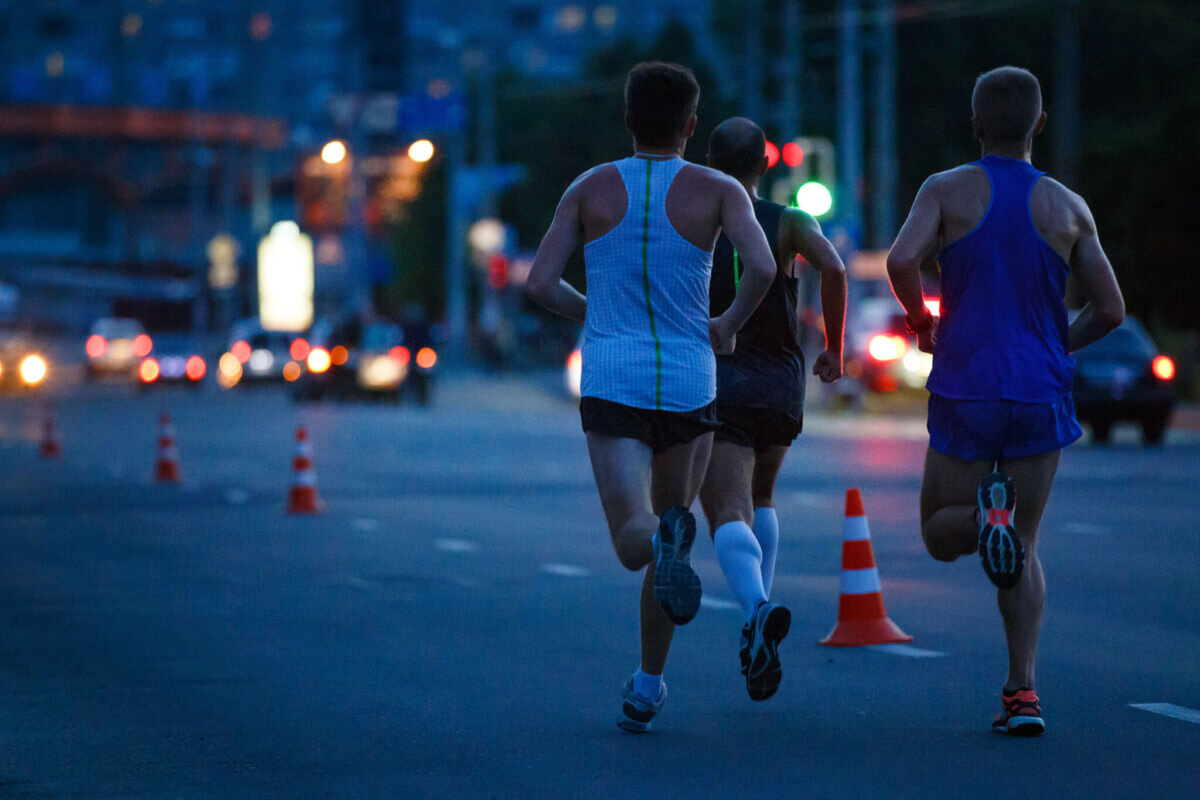 Group of sportsmen running on night road