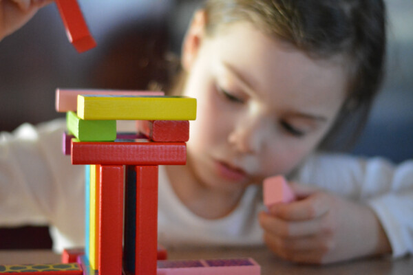 Little girl playing with wooden blocks