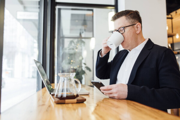 Man drinking coffee while doing work