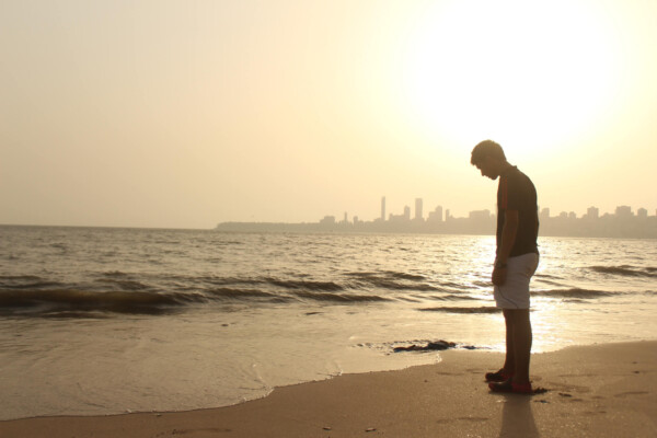 Sad young man at beach alone