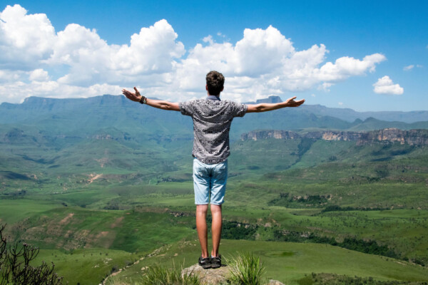 Man with open arms looking at beautiful nature scene