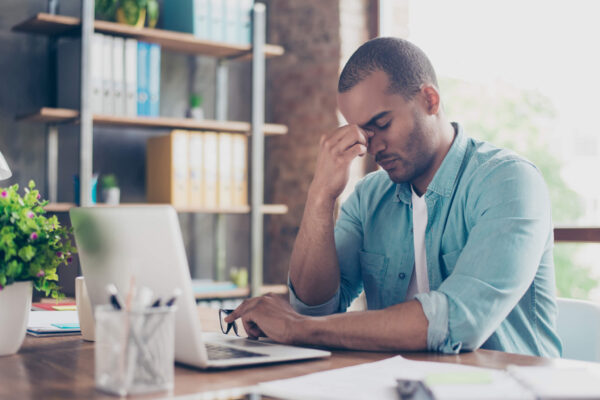 Tired, stressed man trying to do work