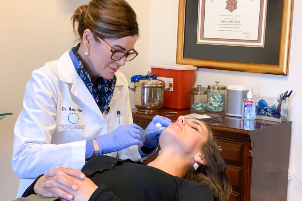Dr. Anne Taylor administers lip injections to a patient