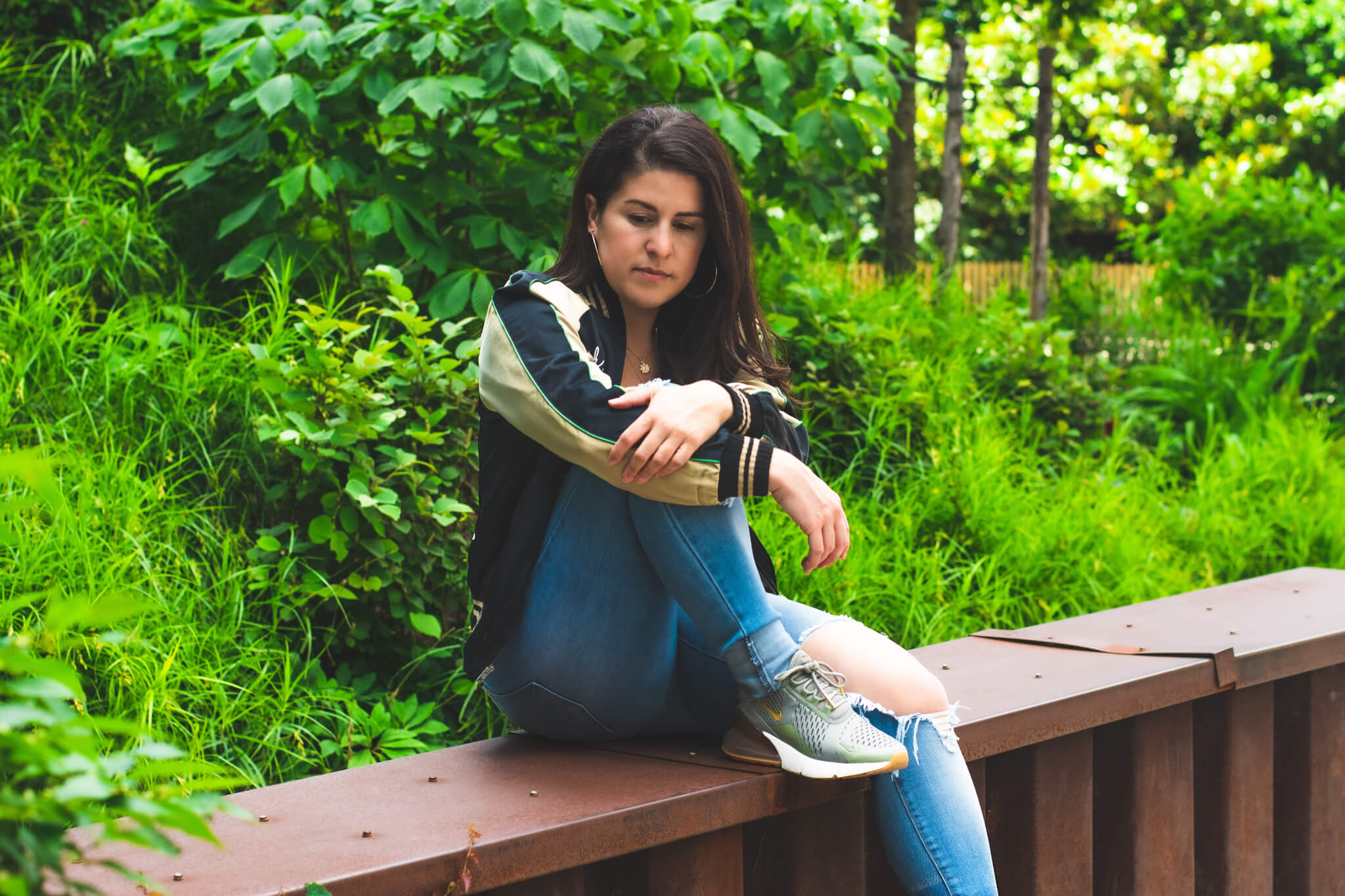 Sad woman sitting alone on a ledge