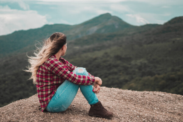 Woman sitting alone on a mountain