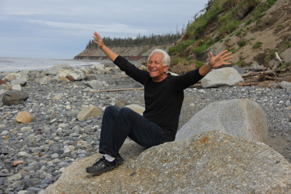 Baby boomer, older adult sitting happily at beach