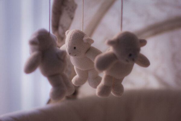 Stuffed bears hanging from baby's crib