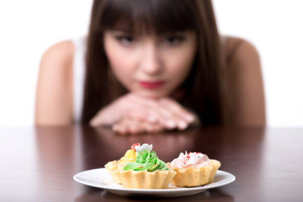 Self-control: Woman resisting temptation to eat cake