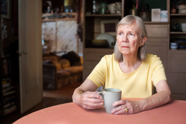 Sad, older woman sitting at table
