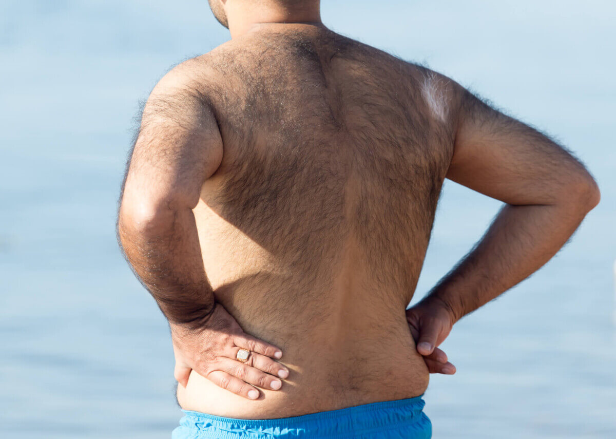Hairy man standing on the beach