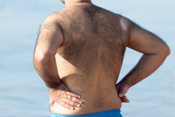 Hairy man standing on the beach