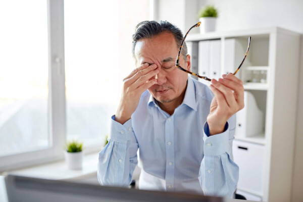 Tired, stressed man sitting at desk at work