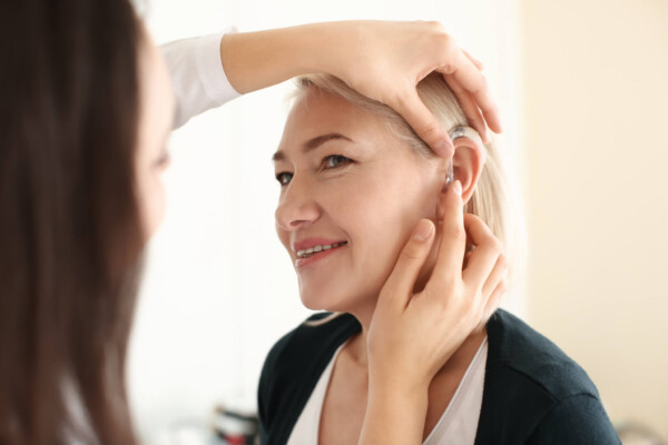 Hearing aid being put in woman's ear