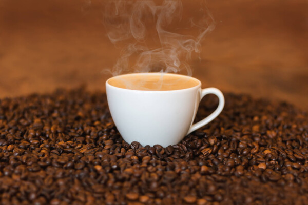 Cup of coffee in coffee beans