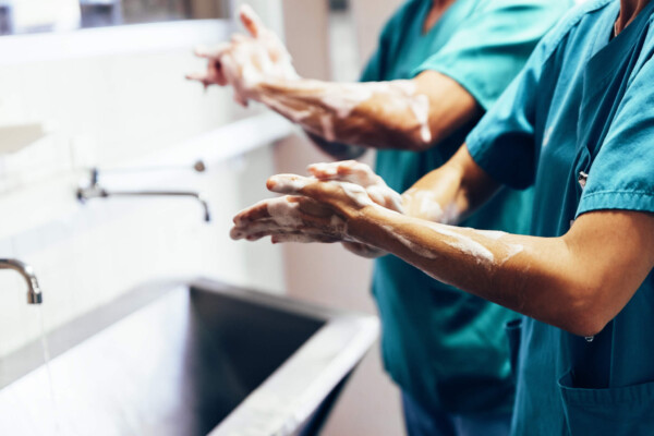 Doctors washing their hands in hospital sink