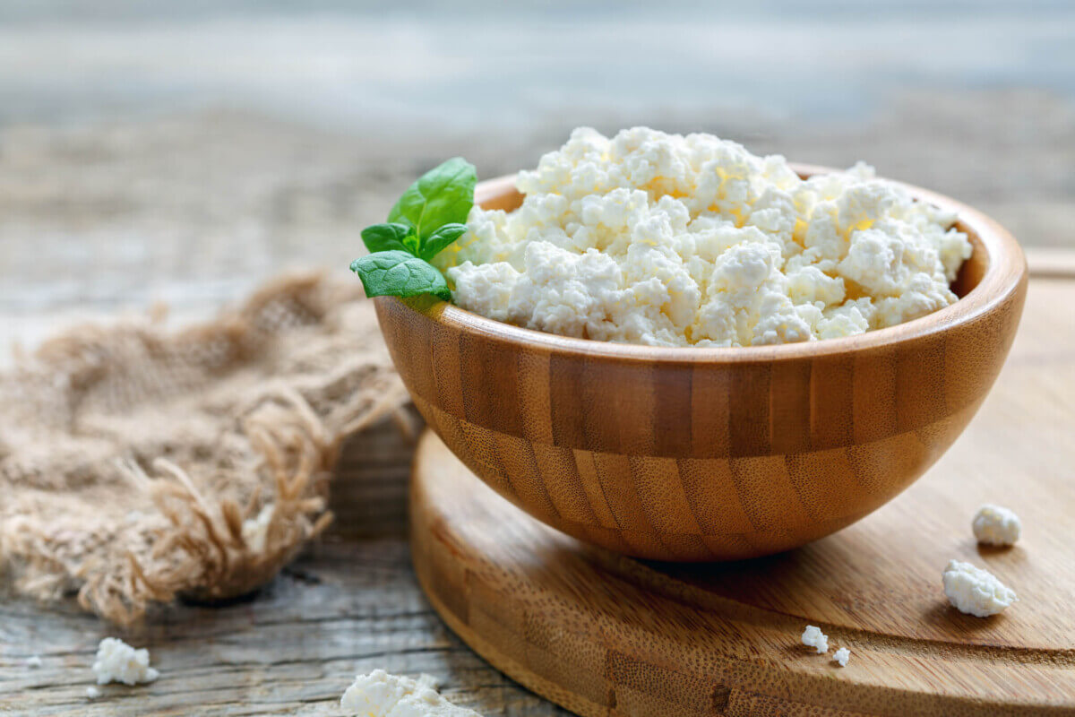 Fresh cottage cheese and mint in a wooden bowl.