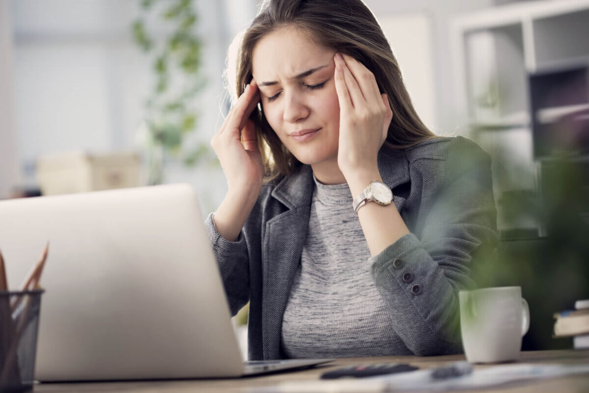 Woman has a headache at her work desk