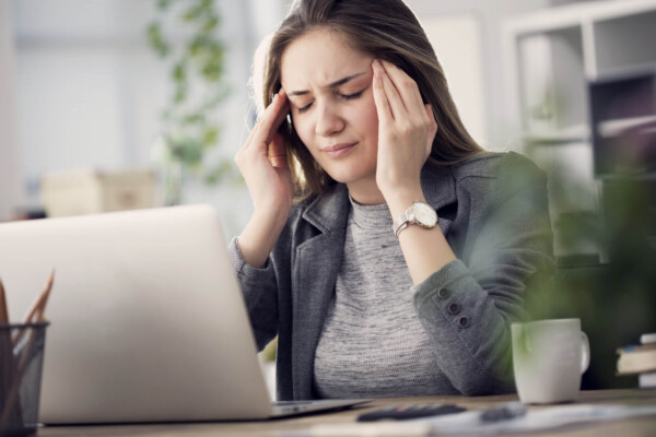 Woman has a headache at her work desk