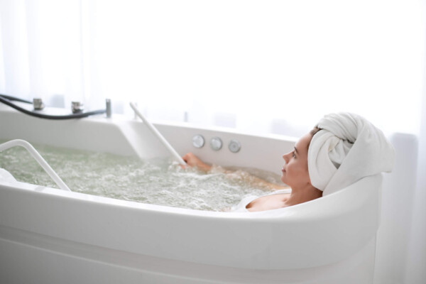 Woman lying in bathtub