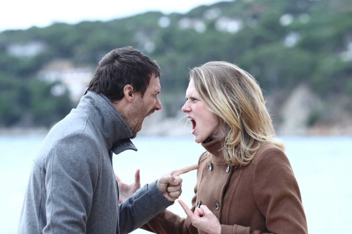 Angry man and woman arguing and shouting in winter