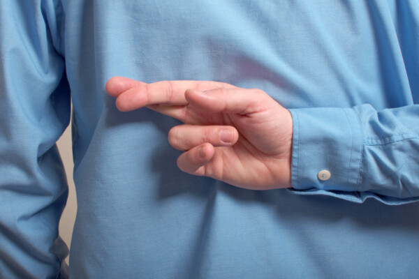 Man lying with fingers crossed behind back