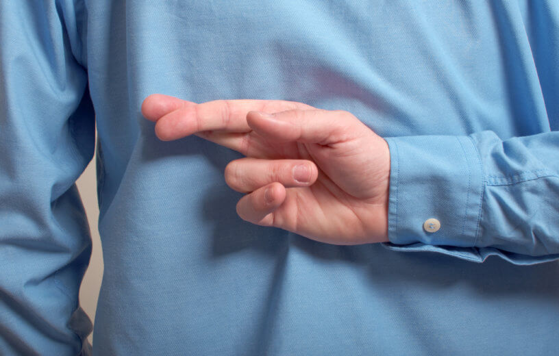 Man lying with fingers crossed behind back
